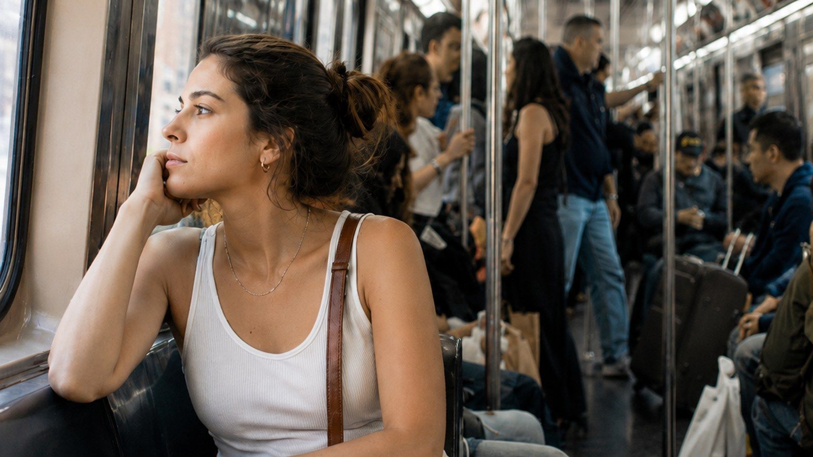 Une jeune femme pensive dans une rame de métro bondée
